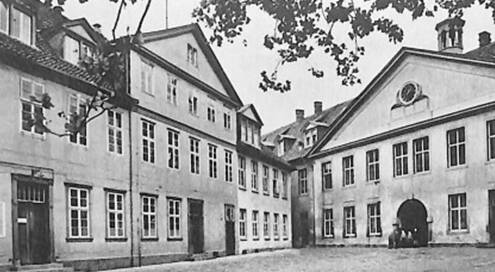 Schwarz-weiß Foto des neuen Gebäudes des Waisenhauses. Klassizistischer Stil, Innenhofansicht, Fassaden und Fenster, oben eine Baumkrone.